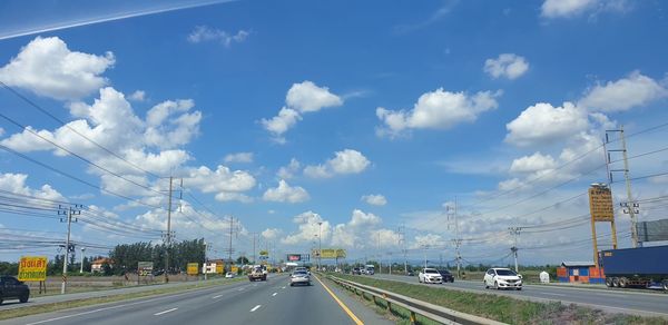 Cars on road against sky in city