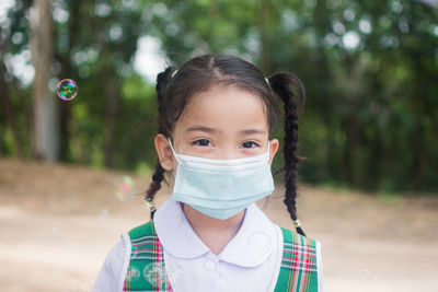 Portrait of girl wearing mask outdoors