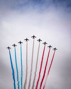 Low angle view of airplanes flying against sky