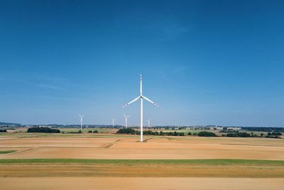 Windmill turbine in the field at summer day. rotating wind generator