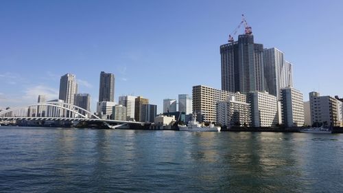 River by buildings against sky in city