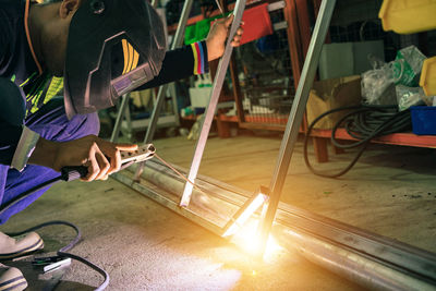 Asian welders wear protective masks and use industrial construction tools.