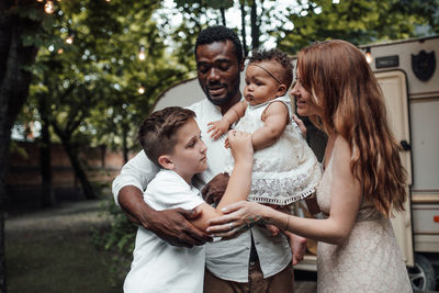 Cheerful family standing against van outdoors