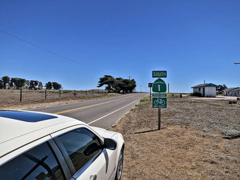 Road sign against clear blue sky