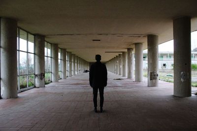 Silhouette man standing walkway under bridge