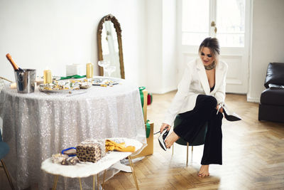 Side view of woman using digital tablet while sitting at home