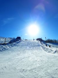 Snow covered land against blue sky