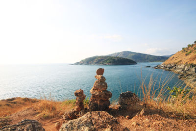 Rear view of rock looking at sea against sky
