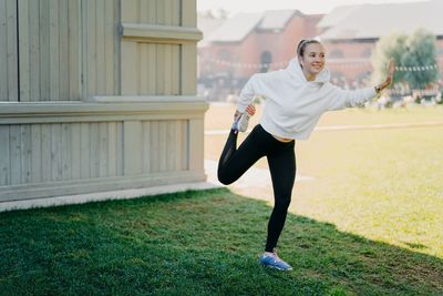 Full length of girl exercising outdoors