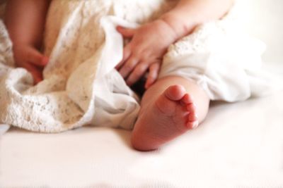 Low section of child on bed at home