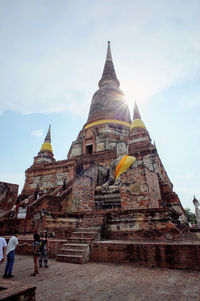 Tourists at temple against sky