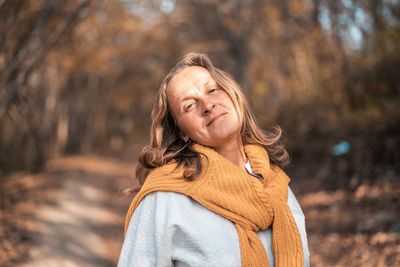 Portrait of woman standing against tree during winter