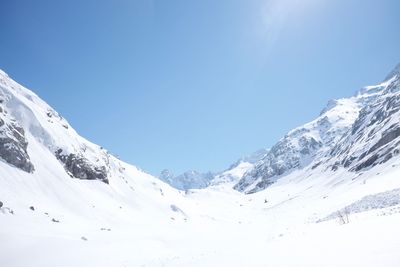 Scenic view of snowcapped mountains against clear blue sky