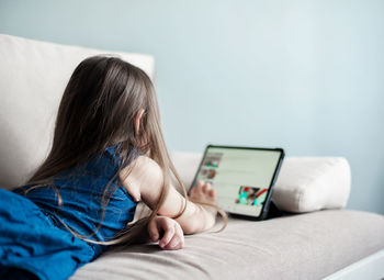 Midsection of woman using mobile phone while sitting on sofa