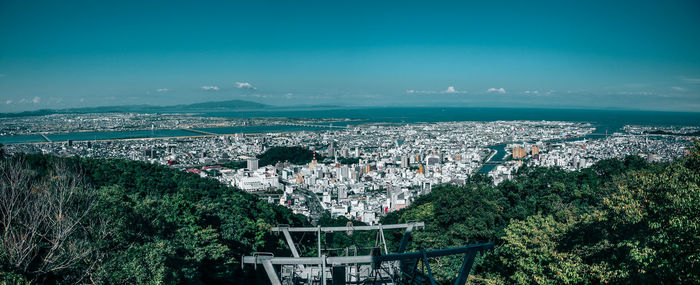 Panoramic view of cityscape against blue sky