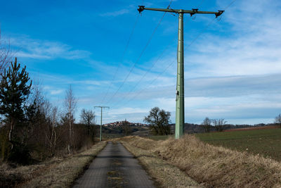 Road amidst field against sky