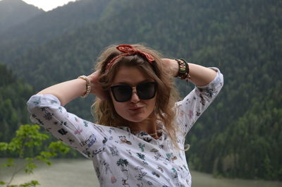 Portrait of young woman wearing sunglasses standing outdoors