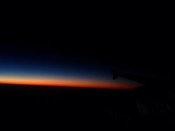 Airplane flying in sky at sunset