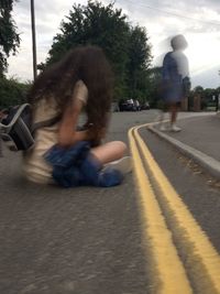 Rear view of man riding motorcycle on street