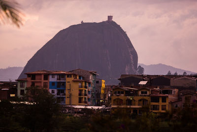 View of buildings in town against cloudy sky