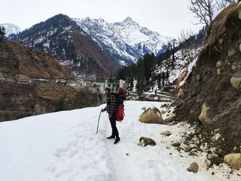 Full length of man standing on snow covered land during winter