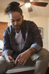 Young man sitting on a kitchen bench.