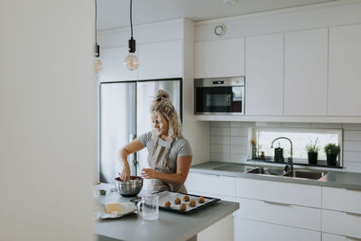 Woman preparing cookies in kitchen