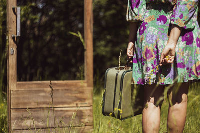 Low section of woman standing by plants