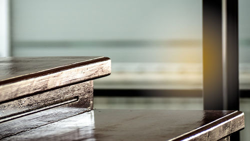 Close-up of wooden table by sea against sky