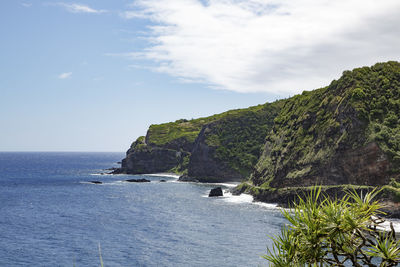 Scenic view of sea and cliff against sky