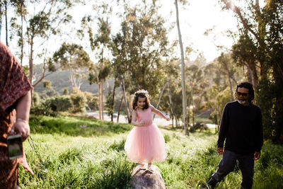 Aunt, uncle and niece walking in field