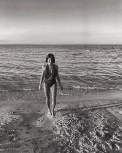 Full length of woman on beach against sky