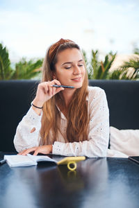 Young woman using smart phone on table