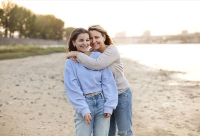 Portrait of smiling woman standing at shore