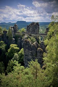 Scenic view of rocks and trees against sky