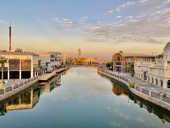 Reflection of buildings in city at sunset