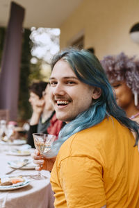 Portrait of smiling friends sitting at restaurant