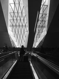 Rear view of woman on escalator