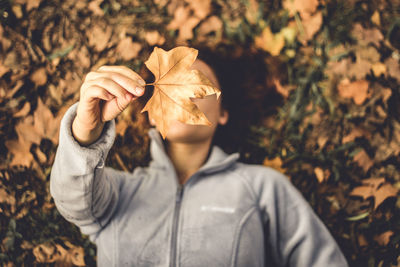 Young woman holding autumn leaves