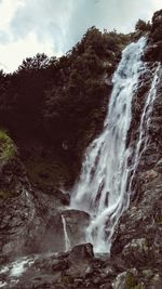 Scenic view of waterfall against sky