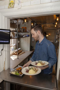 Waiter taking plates with food