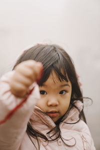 Close-up portrait of cute girl standing outdoors during foggy weather