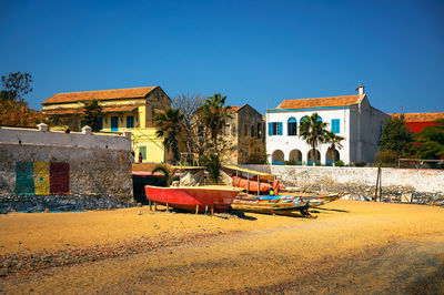 Houses on field against clear blue sky