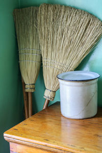 Containers and broom on table at home