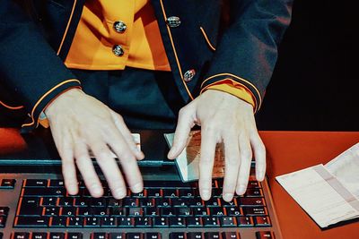 Midsection of man using keyboard