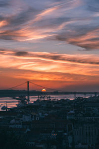 Sunset overlooking lisbon's baixa and 25 april bridge on the tagus river, portugal