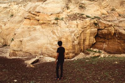 Rear view of man standing on rocky area