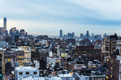 View of cityscape against cloudy sky