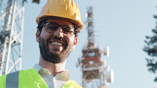 Telecommunications engineer smiles near the transmitting radio antennas
