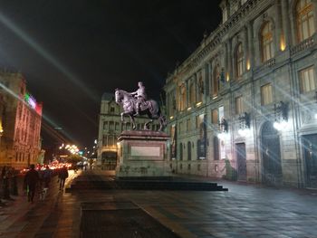 Statue in city at night